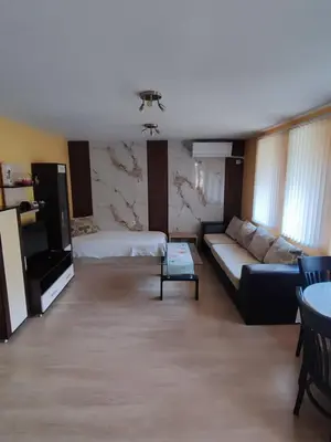 a living room with a couch and a table at Апартамент Родопи in Smolyan