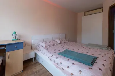 a bedroom with a bed with a green blanket on it at Cozy Apart TOP Center AUBG Free Garage Parking in Blagoevgrad
