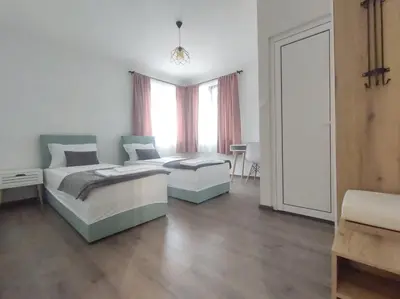 a bedroom with two beds and a large window at Cozy Rooms Panagyurishte in Panagyurishte