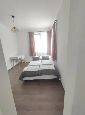 a bedroom with a large bed and a window at Cozy Rooms Panagyurishte in Panagyurishte