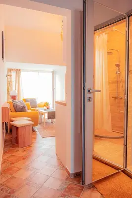 a living room with a shower and a glass door at Pumpkin Spiced Suite with Own Parking and Office Setup in Sofia