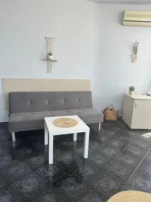 a living room with a couch and a table at Dezudava Family Hotel in Sandanski