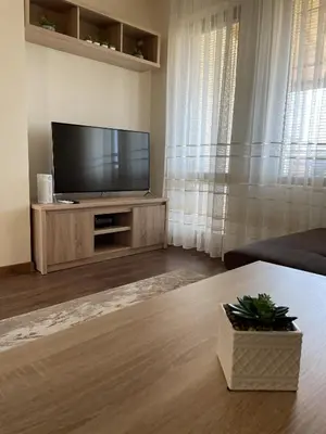 a living room with a flat screen tv on a entertainment center at Panorama view apartment in Sandanski