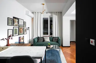 a living room with a green couch and a table at Central Art-Inspired Flat with Private Garage in Sofia