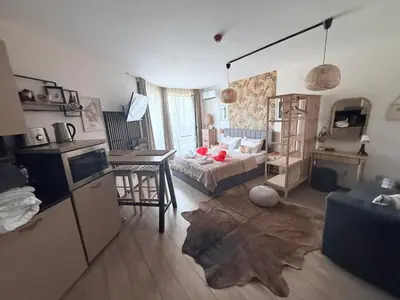 a living room with a bed and a table in it at Luxury Studio in Alpinе Lodge FREE SPA in Bansko