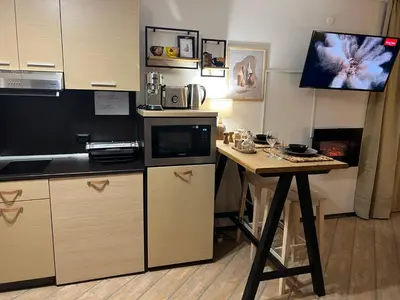 a small kitchen with a table and a microwave at Luxury Studio in Alpinе Lodge FREE SPA in Bansko