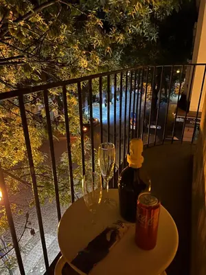 a table with a glass and a bottle of wine on a balcony at The Heart of Old Sofia (Shipka Street 24) in Sofia