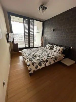 a bedroom with a bed with a blue and white comforter at Silver city in Sofia