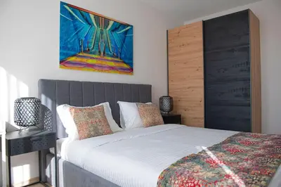 a bedroom with a bed and a painting on the wall at Madrid: A modern 2-bedroom apartment with parking in Sofia