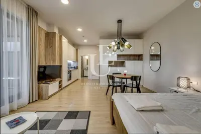a living room with a bed and a dining room at Geneva: A charming patio studio with private parking! in Sofia