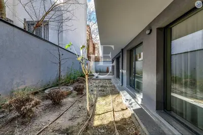 a small tree in the courtyard of a building at Geneva: A charming patio studio with private parking! in Sofia