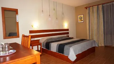 a bedroom with a bed and a table and a desk at Хотел Стиляна/Hotel Stilyana in Devin