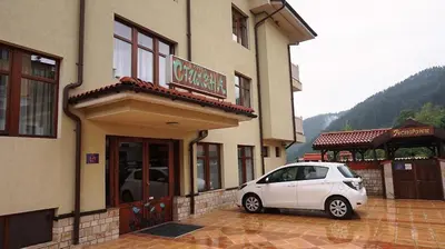 a white car parked in front of a building at Хотел Стиляна/Hotel Stilyana in Devin