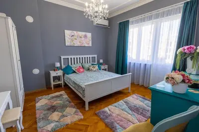 a bedroom with a bed with blue walls and a chandelier at Beauty downtown - TOP CENTER in Sofia