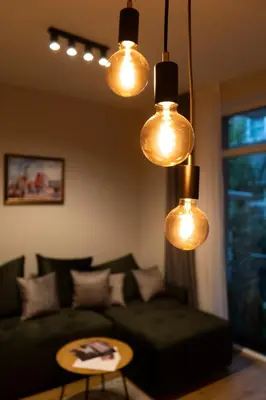 a living room with a green couch and lights at Urban Elegance by Eagles' Bridge in Sofia