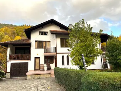 a white house with a balcony and a driveway at Vila Omainiche Ribarica in Ribarica