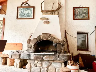 a stone fireplace in a living room withartifactsartifacts at Vila Omainiche Ribarica in Ribarica