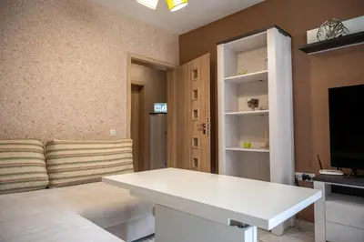 a living room with a white table and a tv at Elegant spotless apartment in Sofia Center in Sofia
