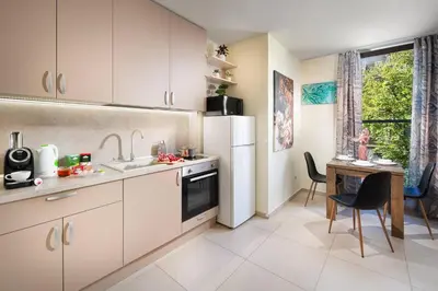 a kitchen with a white refrigerator and a table at New, Modern And Convenient in Sofia