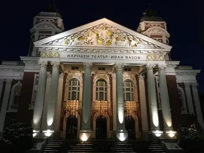 a large building with a sign on it at night at New, Modern And Convenient in Sofia