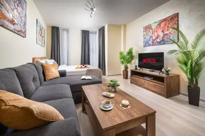 a living room with a couch and a tv at Free Parkingon Premises & Enjoy in Sofia