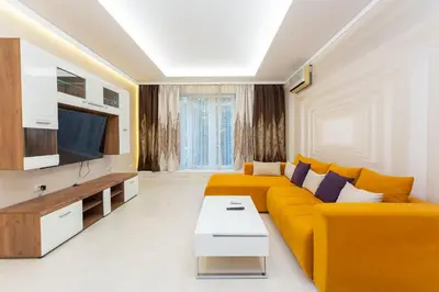 a living room with a yellow couch and a tv at Central Vitosha Apartment in Sofia