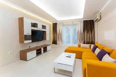 a living room with a yellow couch and a tv at Central Vitosha Apartment in Sofia