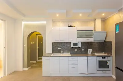 a kitchen with white cabinets and a sink at Central Vitosha Apartment in Sofia