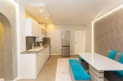 a kitchen with white cabinets and a refrigerator at Central Vitosha Apartment in Sofia
