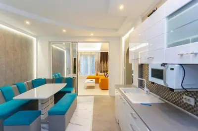 a room with blue chairs and a kitchen with a couch at Central Vitosha Apartment in Sofia