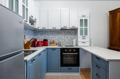 a blue and white kitchen with white cabinets at Alla Prima - 1BD Flat in Sofia Centre by Flat Mаnager in Sofia
