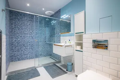 a bathroom with a sink and a shower with blue tiles at Alla Prima - 1BD Flat in Sofia Centre by Flat Mаnager in Sofia