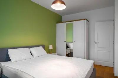 a bedroom with a white bed and a green wall at Alla Prima - 1BD Flat in Sofia Centre by Flat Mаnager in Sofia