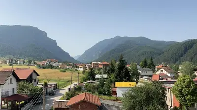 a small town in a valley with mountains in the background at Alpine Nest: 6km to ski slopes in Beli Iskar