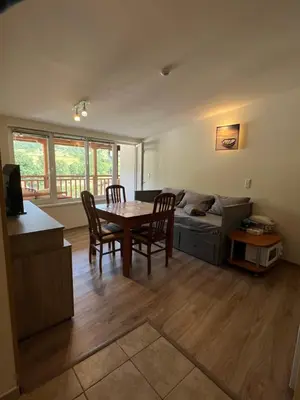 a living room with a table and chairs and a couch at Alpine Nest: 6km to ski slopes in Beli Iskar