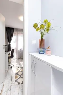 a white kitchen with a vase of flowers on a counter at Super Center flat Parchevich in Plovdiv