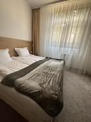 a bedroom with a large bed with a window at Апартхотел Флора 213Б in Borovets