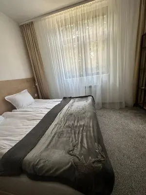 a large bed in a bedroom with a window at Апартхотел Флора 213Б in Borovets