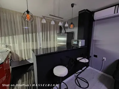a kitchen with a counter and two stools in it at Тристаен апартамент в центъра in Sofia