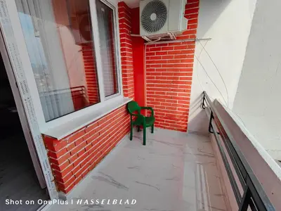 a green chair sitting on the side of a building at Тристаен апартамент в центъра in Sofia