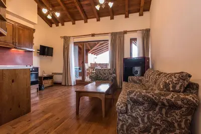 a living room with a couch and a table at Уютен апартамент с гледка в к-с Пирин Голф in Razlog