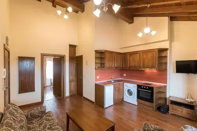 a large room with a kitchen with wooden cabinets at Уютен апартамент с гледка в к-с Пирин Голф in Razlog