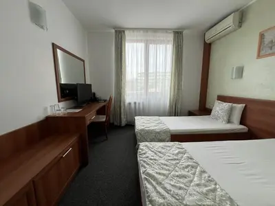 a hotel room with two beds and a desk at Family Hotel 007 Ivan Dimitrov-Kuklata 15 Str in Sofia