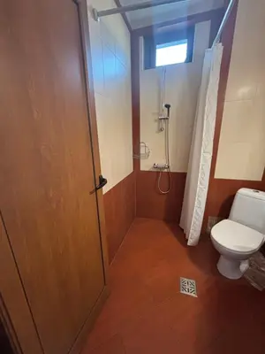 a bathroom with a toilet and a shower and a door at Family Hotel 007 Ivan Dimitrov-Kuklata 15 Str in Sofia
