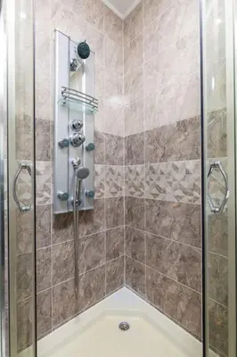 a shower with a glass door in a bathroom at Comfy Apartment with Private Parking in Plovdiv