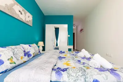 a large bed in a room with a blue wall at Comfy Apartment with Private Parking in Plovdiv