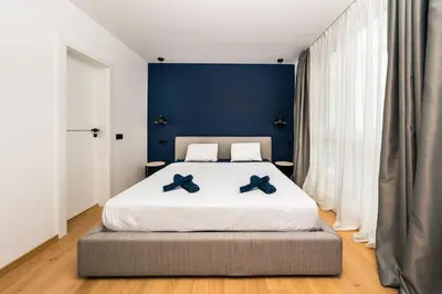 a bedroom with a large bed with blue walls at Vitosha Apartment With Parking in Sofia