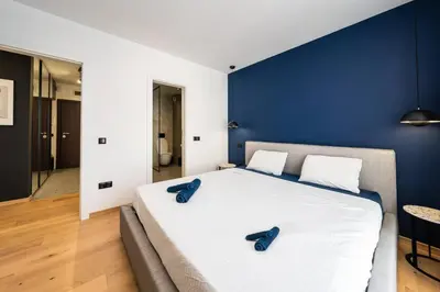 a bedroom with a large bed with blue walls at Vitosha Apartment With Parking in Sofia