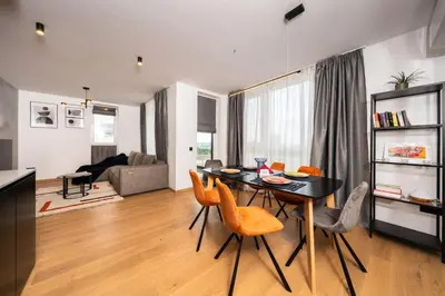 a kitchen and living room with a table and chairs at Vitosha Apartment With Parking in Sofia