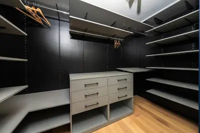 a walk in closet with black walls and white cabinets at Vitosha Apartment With Parking in Sofia